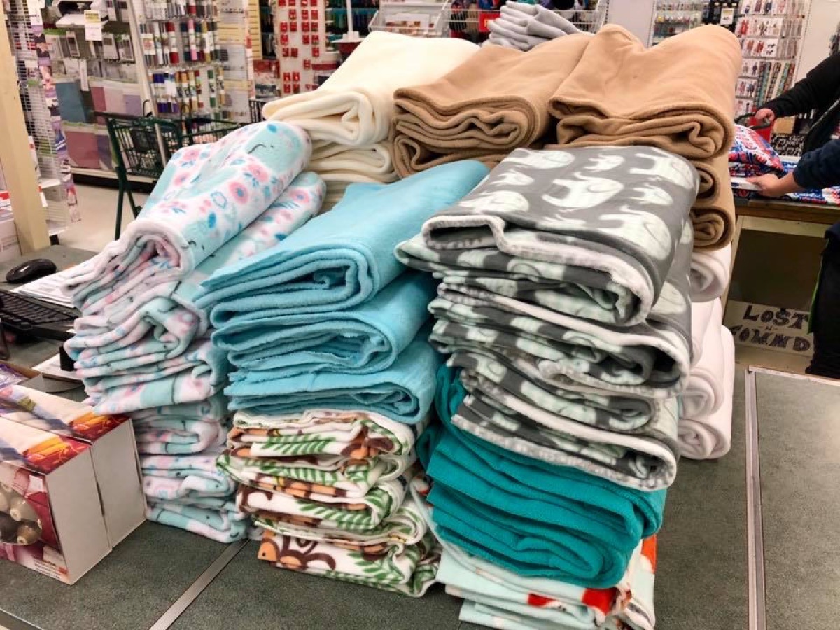 Stacks of patterned fleece fabric at a craft store